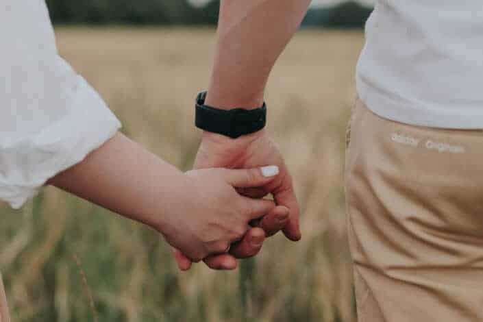 Couple in white shirt holding each hands