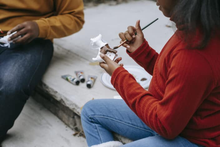Creative black teenagers enjoying handicraft in yard