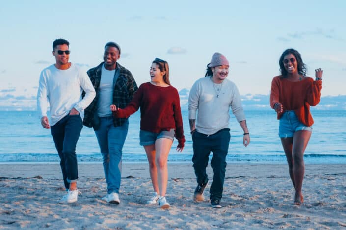 group of people walking on the beach