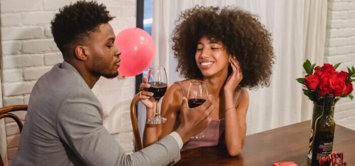African American couple drinking wine at wooden table