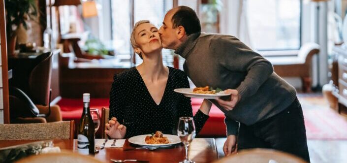 Loving man kissing wife with dinner