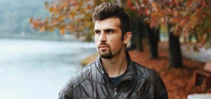 Man in Leather Standing Near Lake