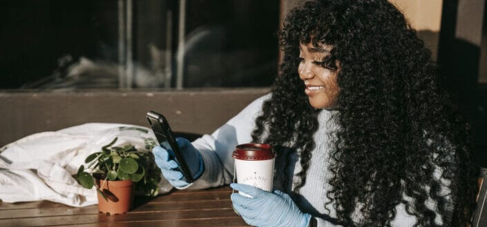 Beautiful curly haired girl smiling over a message on her phone