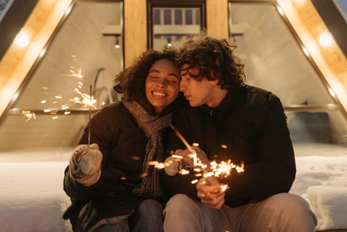 Couple sweetly lighting fireworks on a snowy night