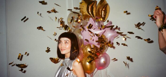 Woman in Silver-blouse Holding Balloons