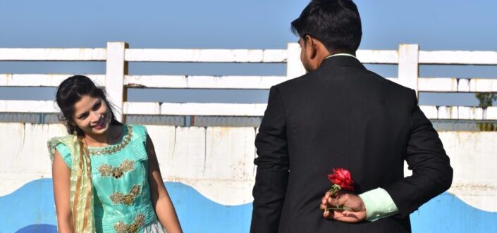 Man hiding a flower behind him