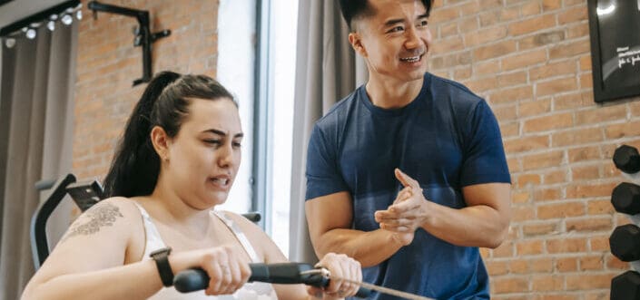 Man supporting his woman in working out.