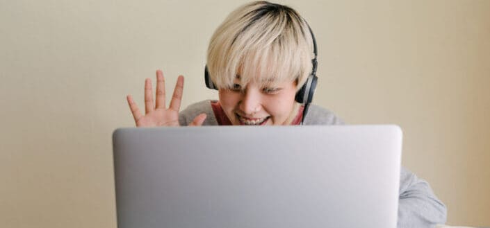 Woman waving on a laptop