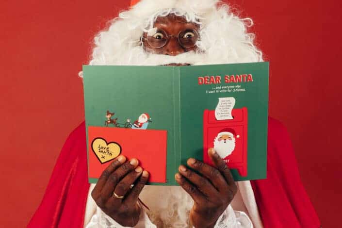black santa with a Christmas book
