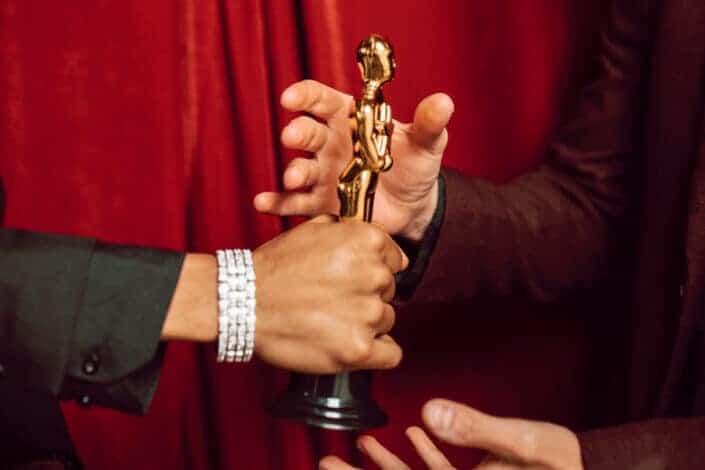 hand with a bracelet holding an award