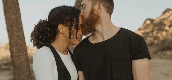 Guy kissing her girl's forehead