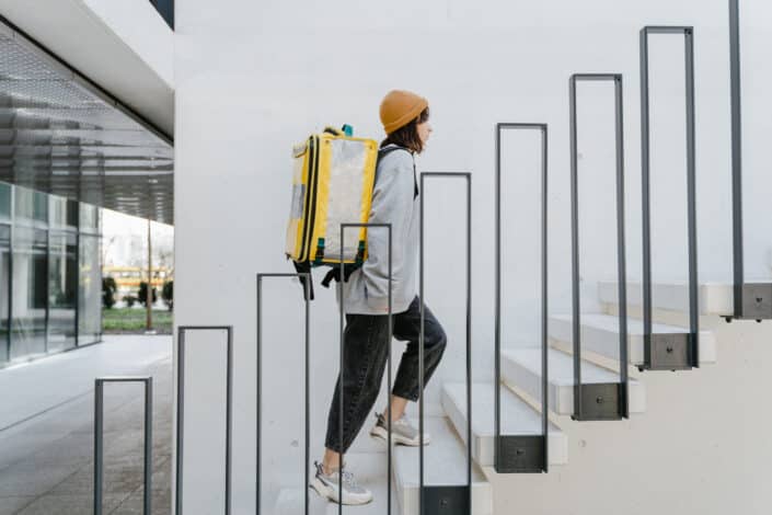 woman with backpack going up the stairs