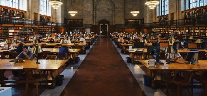 An antique library almost filled with people silently reading books