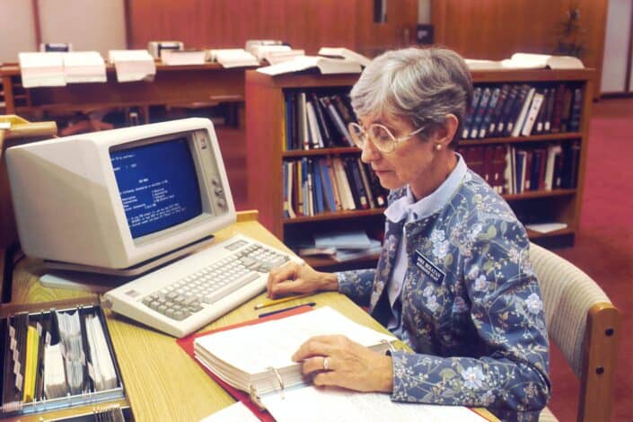 An old woman working with her old model computer