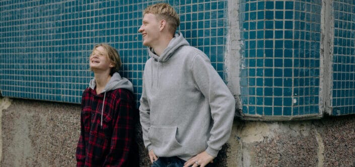 couple laughing together while leaning on wall