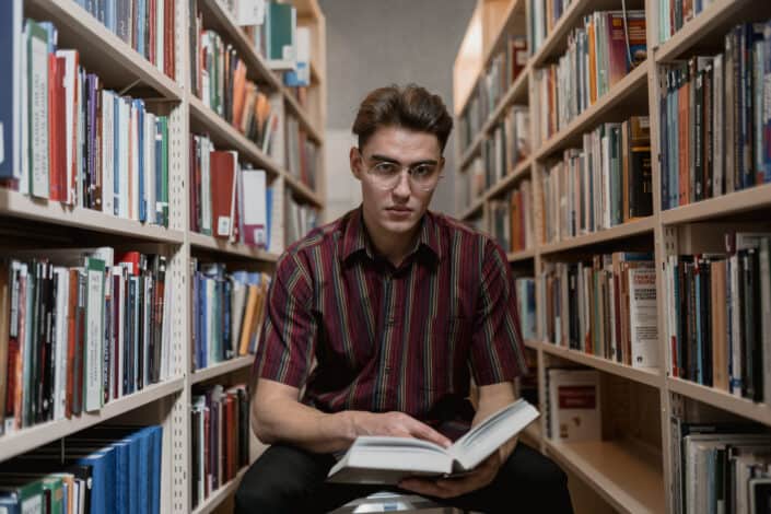 Man reading a book inside a library