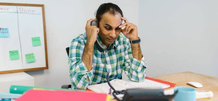 Man in his desk talking to the Phone