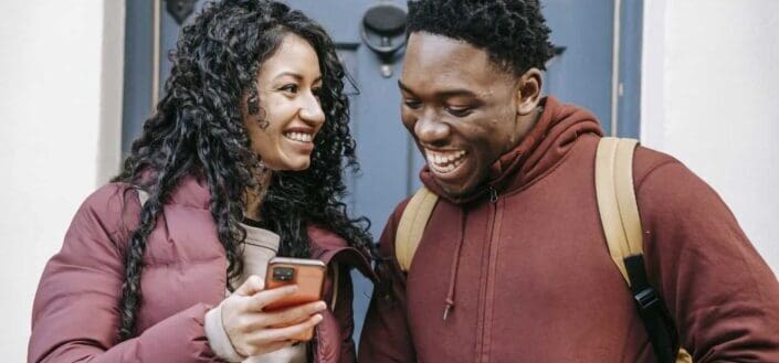 couple sharing smartphone on city street