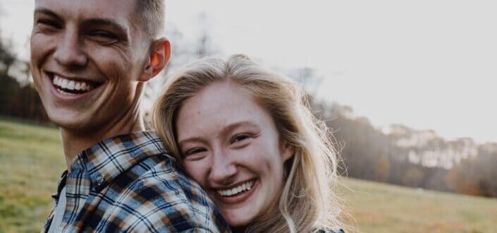 couple kissing on green grass field during daytime