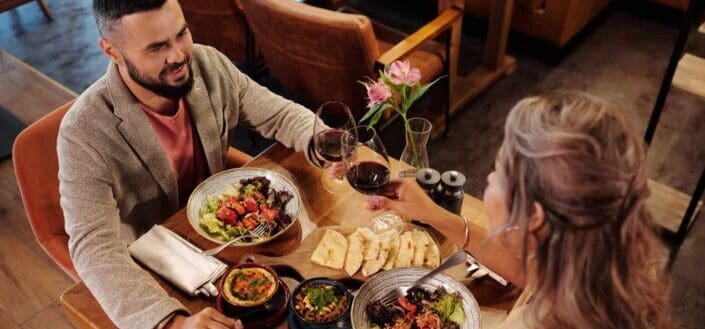 Couple tossing their glass while having dinner 