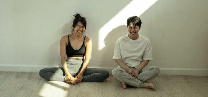 Man and woman having a good laugh while sitting on the floor