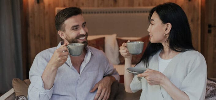 Man and woman drinking coffee while talking to each other