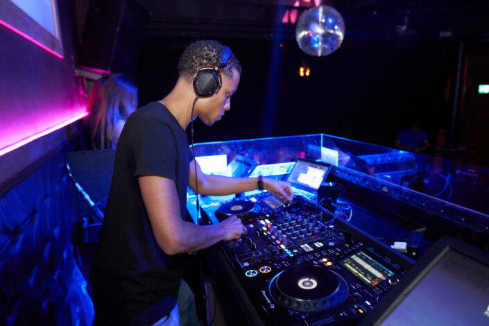 A DJ playing music in a bar.