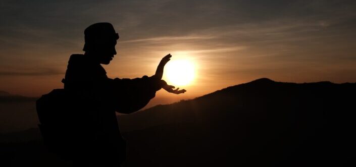 A silhouette of man practicing a kung fu routine.