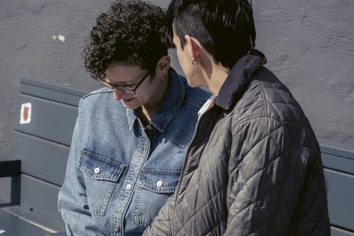 Two people talking seriously while sitting on a bench 