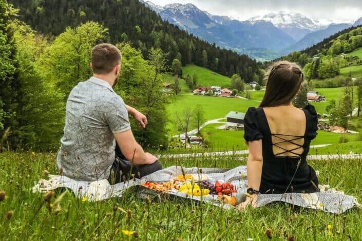 Couple having picnic at beautiful green meadows
