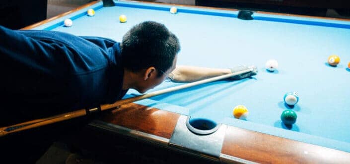 Pool player about to hit the ball