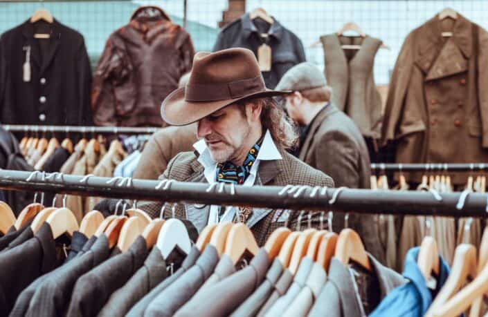 Man in cowboy hat shopping clothes.
