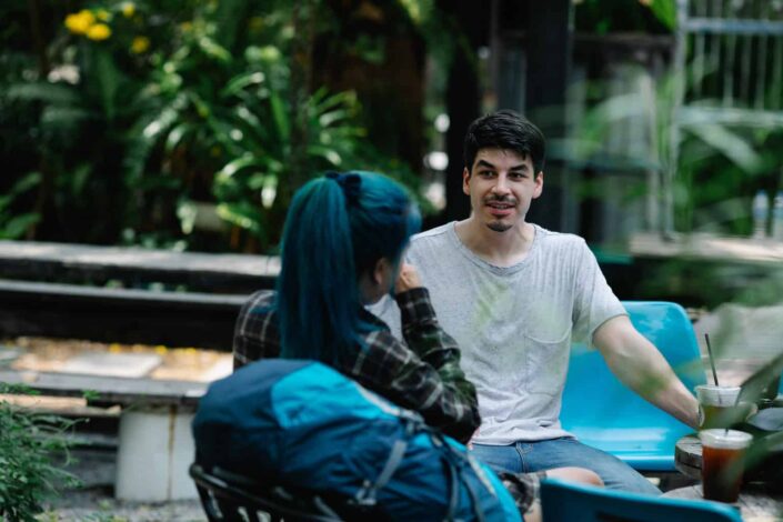 Man and woman chilling outside while drinking coffee