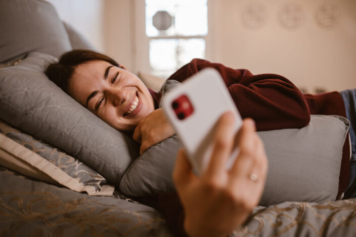 Woman smiling while reading something on her phone