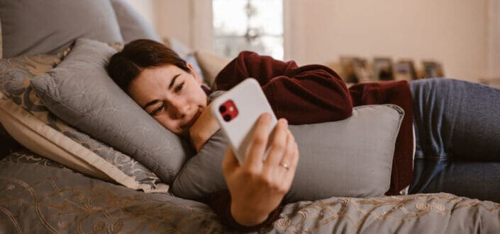 Woman smiling while reading a text message