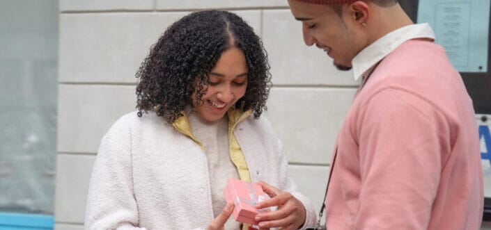 Woman opening a present from her man.