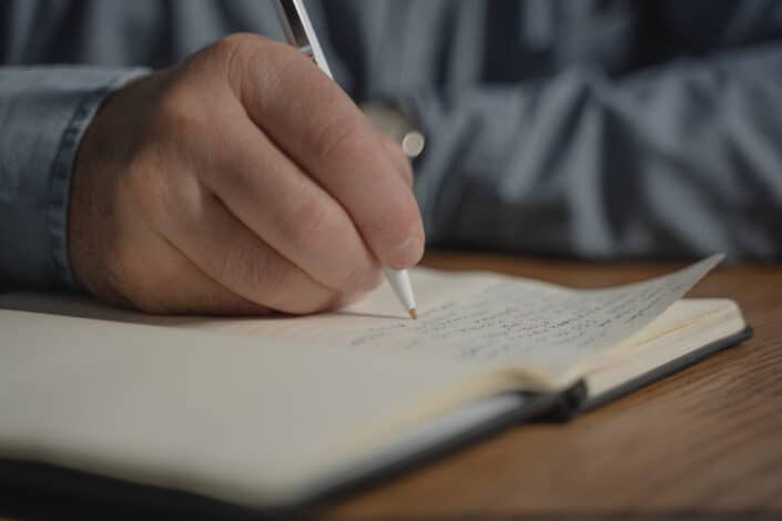 A person writing on a notebook