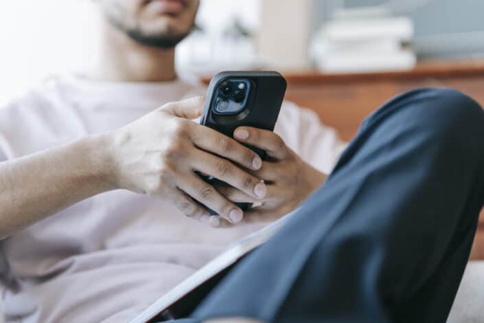 bearded man using smartphone in living room