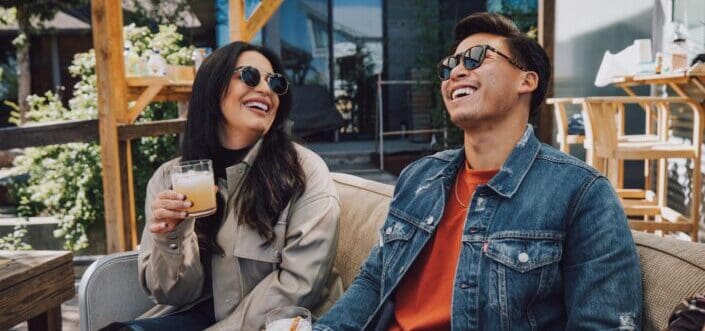 Man And Woman Laughing While Drinking Together