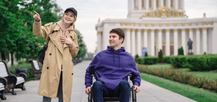 Man in a Wheelchair Asking Direction From a Woman
