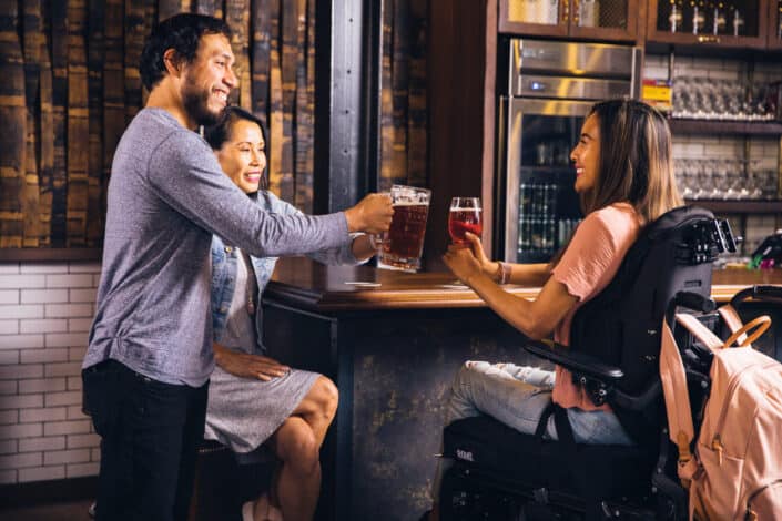 Man Clinking Glasses With Women in a Bar