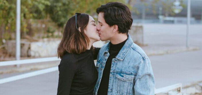 man and woman kissing outside