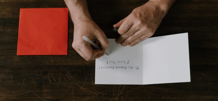 Person Writing on a Card