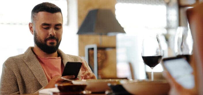 Man Using His Phone while eating