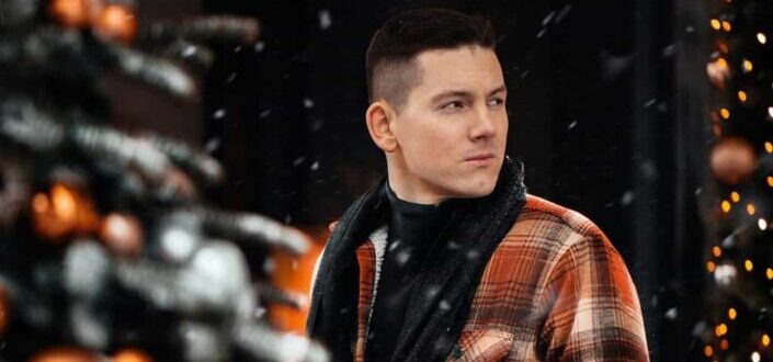 Guy wearing orange checkered winter jacket while outside on a snowy weather