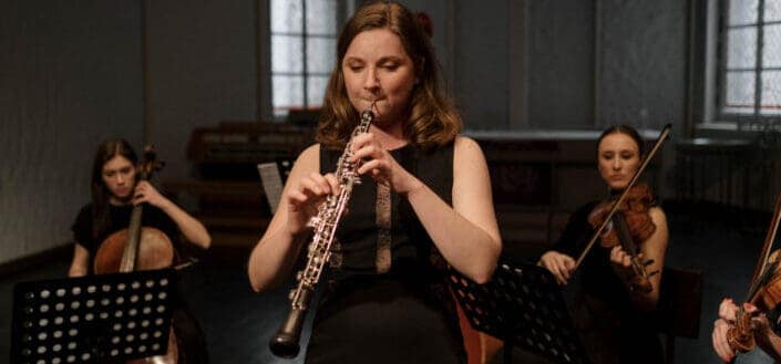 Woman Playing Concert Flute With An Orchestra