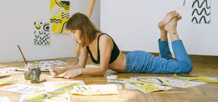 Photo of Woman Lying on Floor While Painting