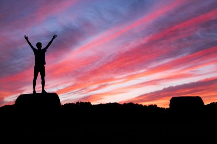 Man on top of a rock at sunset