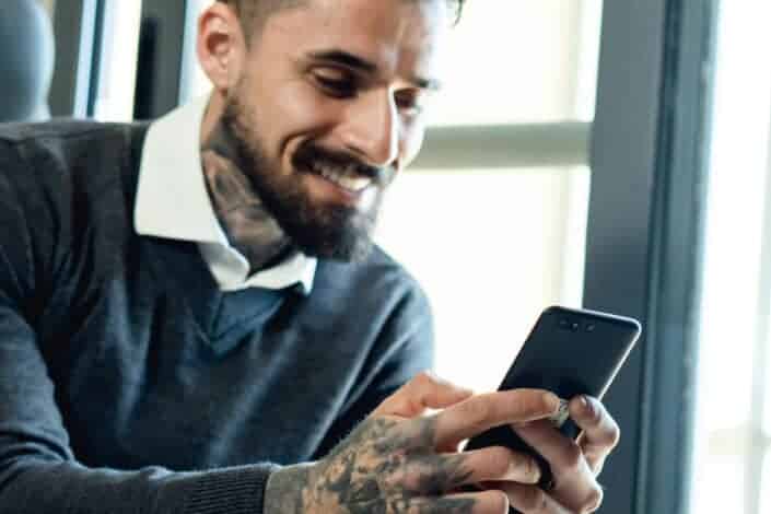 Smiling Bearded Man Using a Cellphone
