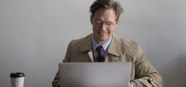Smiling male writer using laptop